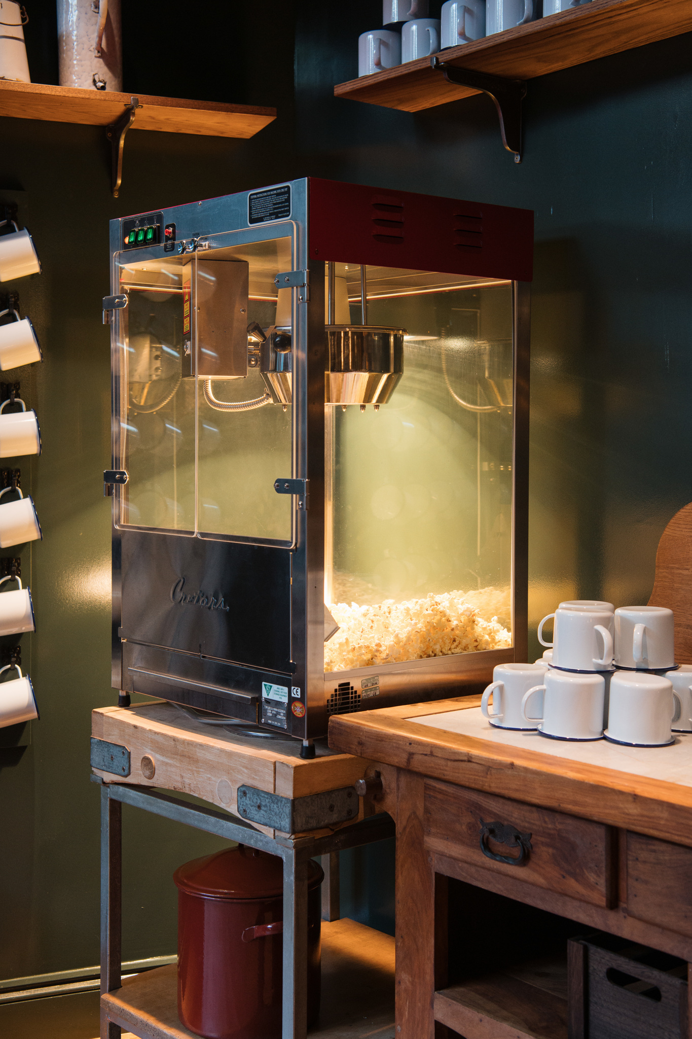 free popcorn machine against a green wall with warm lighting