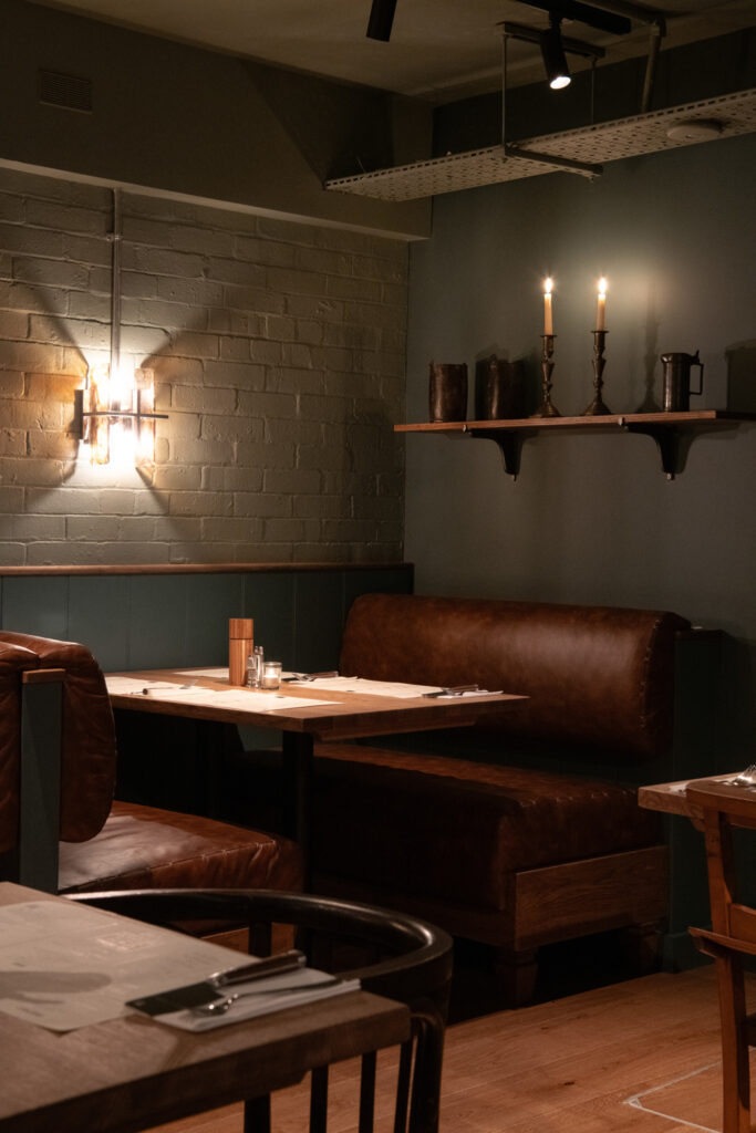 resturant interior with leather booths and warm lighting and candles