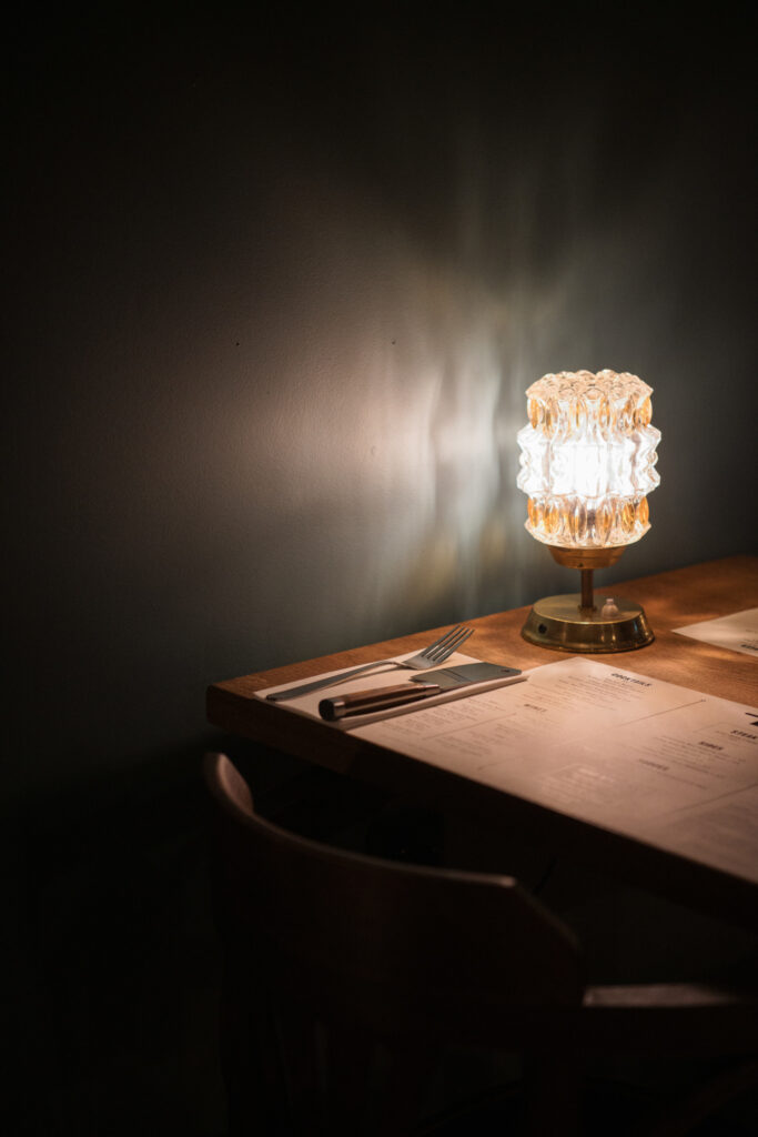 Table with vintage glass lamp decor with moody lighting