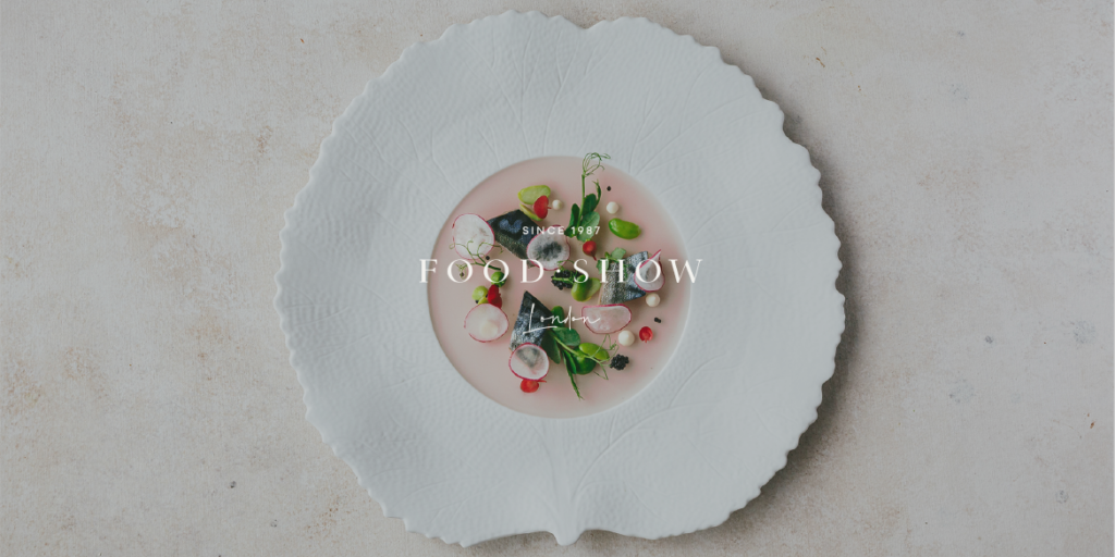 large textured bowl plate with delicate food on it. Food show london logo on top of the plate.