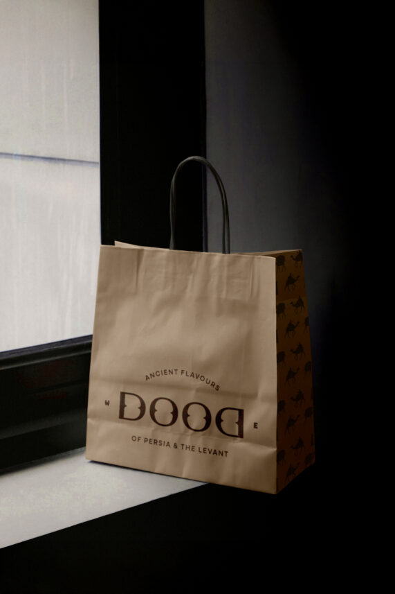 Dood stylish custom design takeaway paper bag against a window